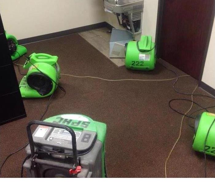 wet commercial carpeting with green servpro industrial equipment