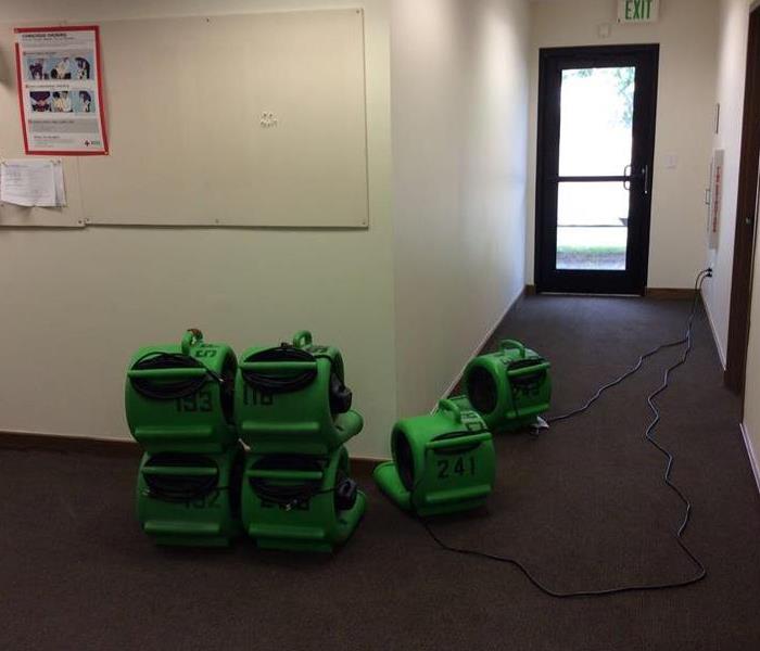 SERVPRO water damage equipment in commercial hallway